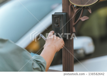 A man in work clothes holding a binder rings the doorbell. 138582642