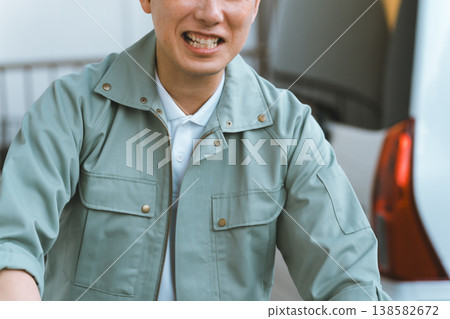 A man in work clothes and a car 138582672