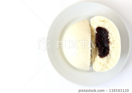 A sesame bean paste bun on a white background, viewed from directly above. A sesame bean paste bun on a white background, viewed from directly above. 138583120