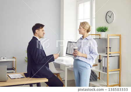 Two colleagues are having friendly conversation in calm atmosphere of their workplace in office. Two colleagues are having friendly conversation in calm atmosphere of their workplace in office. 138583333