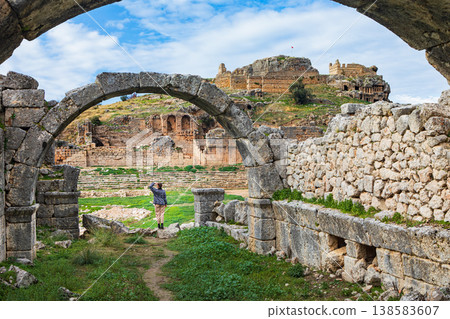 Young child looks at acropolis of ancient Greek city Tlos in Lycia located on Lycian way. Famous historical site In Antalya region. Popular place for family travel on summer vacation. Fethiye, Turkey 138583607