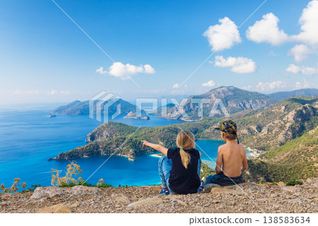 Little kids looking at beautiful view Oludeniz beach, Lycia coast. Summer day walk by Lycian way at family vacation in Mediterranean Sea, Fethye, Antalya region, Turkey 138583634