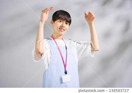 一位二十多歲的男幼教老師,穿著圍裙 一位二十多歲的男幼教老師,穿著圍裙 138583727
