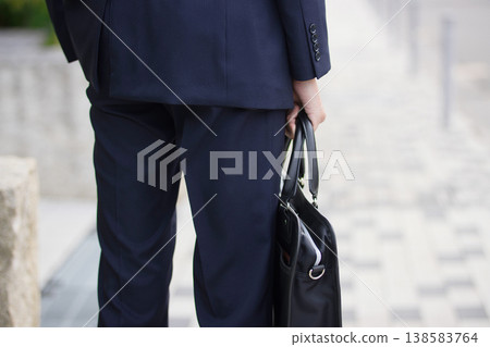A businessman in his twenties walking outdoors A businessman in his twenties walking outdoors 138583764