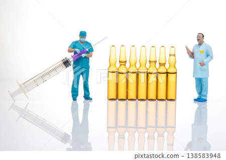 Miniature people with a syringe and vials in a clean setting during a health-related activity Miniature people with a syringe and vials in a clean setting during a health-related activity 138583948