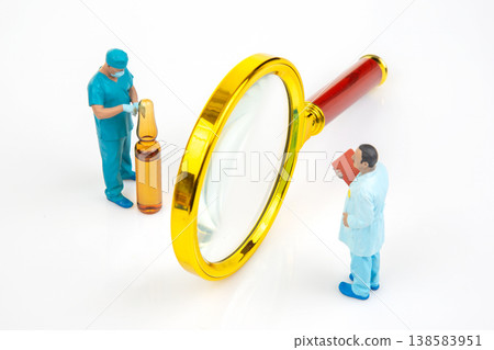 Miniature people examining a vial with a magnifying glass in a lab setting during the daytime Miniature people examining a vial with a magnifying glass in a lab setting during the daytime 138583951