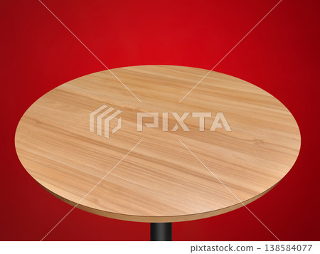 A circular wooden table on a red background. A circular wooden table on a red background. 138584077
