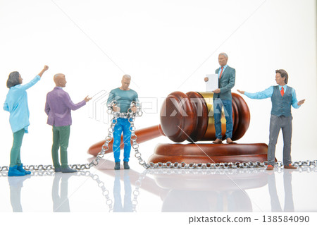 Miniature people engage in a court scene with a gavel, chains, and discussions about justice Miniature people engage in a court scene with a gavel, chains, and discussions about justice 138584090