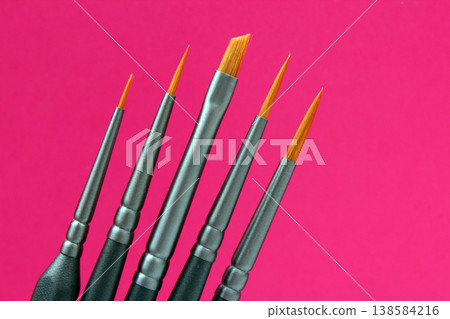 Various paintbrushes arranged in order showing different sizes and shapes against a pink background Various paintbrushes arranged in order showing different sizes and shapes against a pink background 138584216