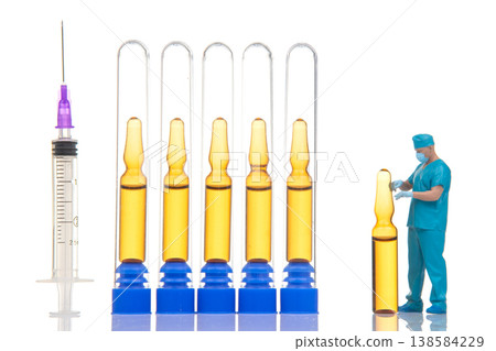 Miniature people working with syringes and vials in a small lab setting during a bright day 138584229