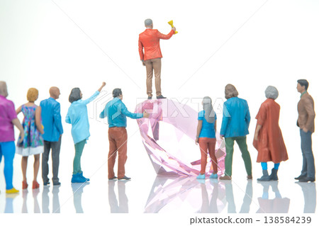 Miniature figurines celebrate success around a large crystal on a clear surface during daylight Miniature figurines celebrate success around a large crystal on a clear surface during daylight 138584239
