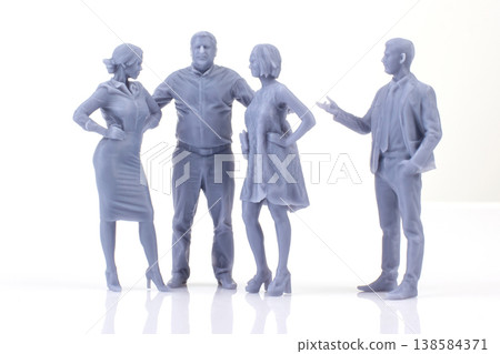 Miniature people stand in group while discussing their plans for the day in a simple indoor setting Miniature people stand in group while discussing their plans for the day in a simple indoor setting 138584371