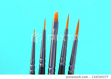 Different sizes of paintbrushes arranged with a blue background showing tools for painting Different sizes of paintbrushes arranged with a blue background showing tools for painting 138584377