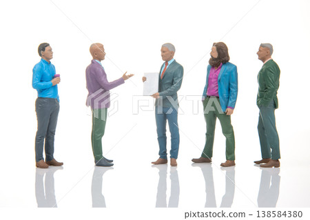 Miniature figures in a business meeting exchanging documents and discussing important topics Miniature figures in a business meeting exchanging documents and discussing important topics 138584380