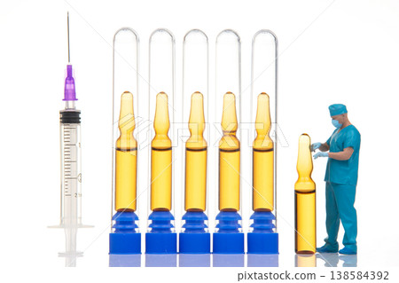 Miniature figures interact with lab equipment and syringes in a science setting during daylight Miniature figures interact with lab equipment and syringes in a science setting during daylight 138584392