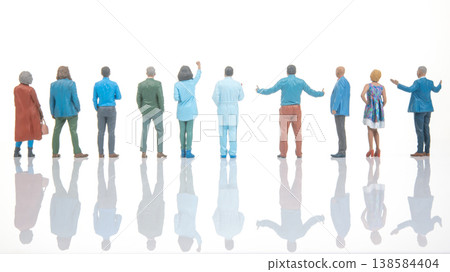 Miniature people standing together and looking at a bright background in a creative display during Miniature people standing together and looking at a bright background in a creative display during 138584404