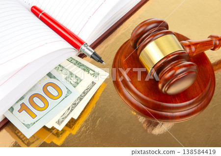 Court gavel rests on golden table near cash, notebook, and pen during legal proceedings Court gavel rests on golden table near cash, notebook, and pen during legal proceedings 138584419