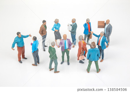 Miniature figurines of people stand in a circle, engaged in conversation Miniature figurines of people stand in a circle, engaged in conversation 138584506