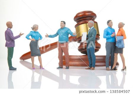Miniature people gather around a gavel while discussing legal matters in a small setting Miniature people gather around a gavel while discussing legal matters in a small setting 138584507