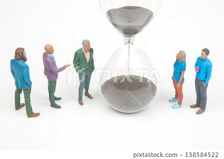 Miniature people gather around hourglass discussing time and importance of moments in life Miniature people gather around hourglass discussing time and importance of moments in life 138584522