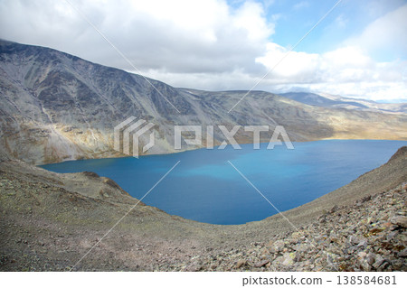 Mountain landscape with lake under cloudy sky in a remote area during daytime Mountain landscape with lake under cloudy sky in a remote area during daytime 138584681