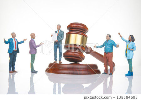 Miniature people gather around gavel in court scene showing legal proceedings and discussions Miniature people gather around gavel in court scene showing legal proceedings and discussions 138584695