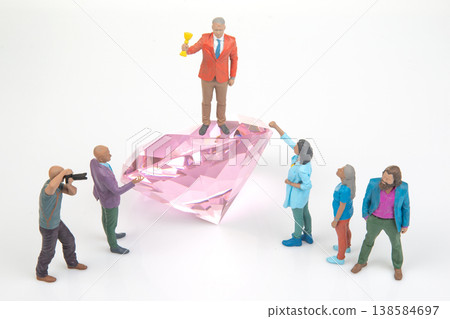 Miniature people celebrating around a large pink diamond during a fun creative scene Miniature people celebrating around a large pink diamond during a fun creative scene 138584697