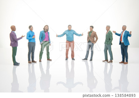 Seven miniature figurines stand in a circle with one figure gesturing while others listen Seven miniature figurines stand in a circle with one figure gesturing while others listen 138584893