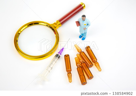 Miniature people with medical tools and vials on a white background in a laboratory setting Miniature people with medical tools and vials on a white background in a laboratory setting 138584902