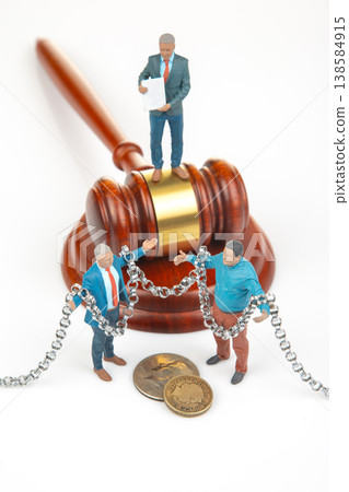Miniature people are in front of a gavel Miniature people are in front of a gavel 138584915