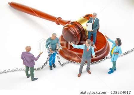 Miniature figures in a legal scene with a gavel, chain, and documents representing a court setting Miniature figures in a legal scene with a gavel, chain, and documents representing a court setting 138584917