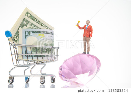 Miniature people and shopping cart with money and gem in bright setting 138585224