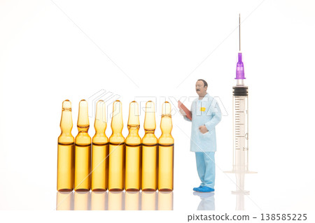 Miniature figures of a doctor preparing for a vaccine injection using small vials  138585225