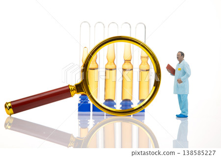 Miniature people examine tiny medicine vials with a large magnifying glass in a lab setting Miniature people examine tiny medicine vials with a large magnifying glass in a lab setting 138585227