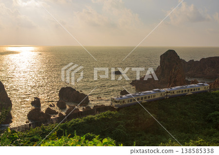 五野線的柴油車組沿著海岸線行駛,以夕陽下波光粼粼的日本海為背景。 五野線的柴油車組沿著海岸線行駛,以夕陽下波光粼粼的日本海為背景。 138585338