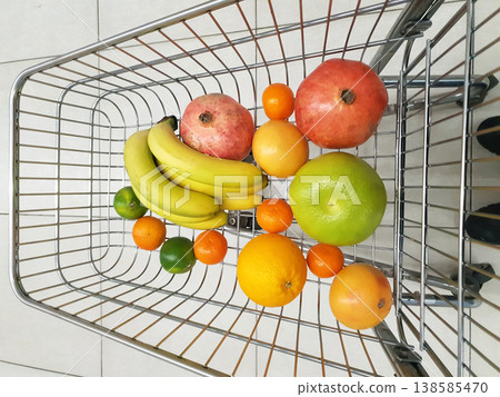 Fresh fruits in a shopping cart during a grocery visit in a store on a bright day Fresh fruits in a shopping cart during a grocery visit in a store on a bright day 138585470