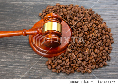 Coffee beans surround a gavel on a wooden surface during a legal discussion about coffee regulations Coffee beans surround a gavel on a wooden surface during a legal discussion about coffee regulations 138585476