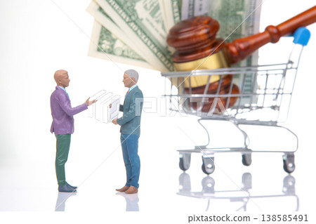 Two figures discuss legal matters with cash and a gavel in a shopping cart on a white background Two figures discuss legal matters with cash and a gavel in a shopping cart on a white background 138585491