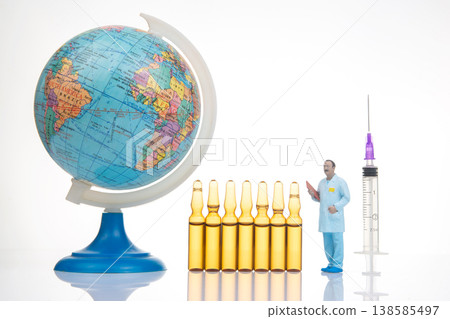 Models of a globe, vials, a doctor figure, and a syringe in a scientific setting in a studio Models of a globe, vials, a doctor figure, and a syringe in a scientific setting in a studio 138585497