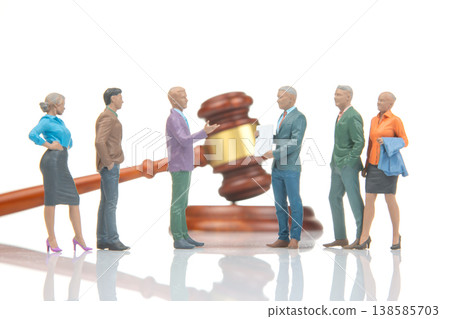 Miniature people engage in a discussion about legal matters with a gavel in the background during Miniature people engage in a discussion about legal matters with a gavel in the background during 138585703