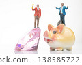 Miniature people hold trophies as they stand on a large diamond and a piggy bank in creative  138585722
