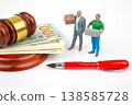 Miniature people carry boxes next to money and a gavel during a business discussion in a courtroom  138585728