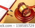 Gavel and pen on legal documents in court setting during daytime 138585729