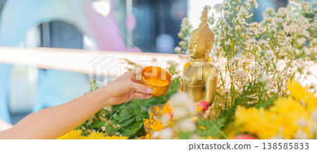 Happy Songkran festival day in Thailand or Thai Happy New Year. hand pouring water on golden Buddha statue with flowers and garland in. Holiday and culture concept Happy Songkran festival day in Thailand or Thai Happy New Year. hand pouring water on golden Buddha statue with flowers and garland in. Holiday and culture concept 138585833