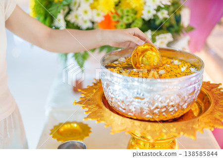Happy Songkran festival day in Thailand or Thai Happy New Year. hand pouring water on golden Buddha statue with flowers and garland in. Holiday and culture concept 138585844