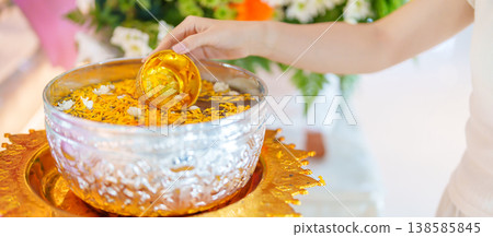 Happy Songkran festival day in Thailand or Thai Happy New Year. hand pouring water on golden Buddha statue with flowers and garland in. Holiday and culture concept Happy Songkran festival day in Thailand or Thai Happy New Year. hand pouring water on golden Buddha statue with flowers and garland in. Holiday and culture concept 138585845