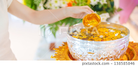 Happy Songkran festival day in Thailand or Thai Happy New Year. hand pouring water on golden Buddha statue with flowers and garland in. Holiday and culture concept 138585846