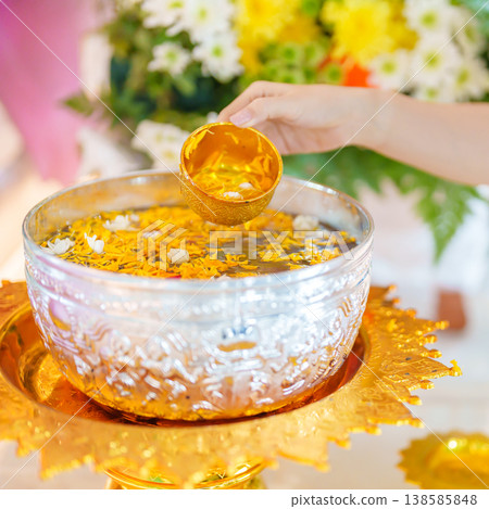 Happy Songkran festival day in Thailand or Thai Happy New Year. hand pouring water on golden Buddha statue with flowers and garland in. Holiday and culture concept 138585848