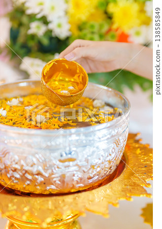 Happy Songkran festival day in Thailand or Thai Happy New Year. hand pouring water on golden Buddha statue with flowers and garland in. Holiday and culture concept 138585849