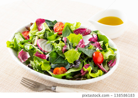 桌上擺著蔬菜沙拉和橄欖油。 138586183